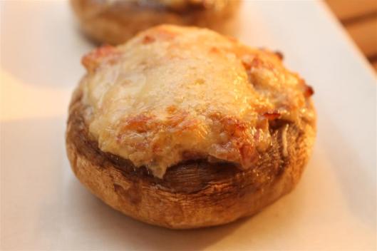 Champiñón relleno de chalota, crème fraîche y jamón serrano, con queso Comté