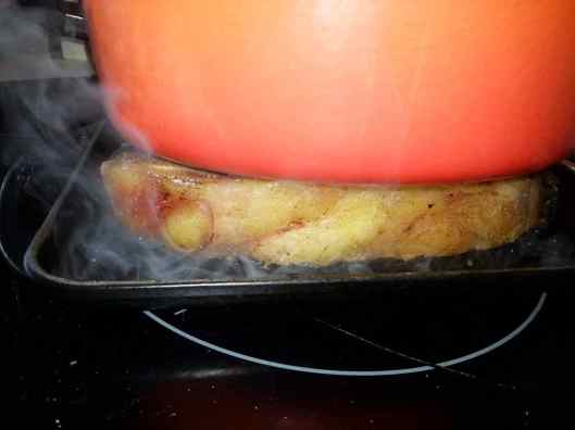 Chuletón dorándose en parrilla con cocotte encima