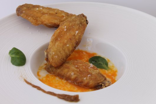 Alitas de pollo, huevo roto y puré de ajo confitado