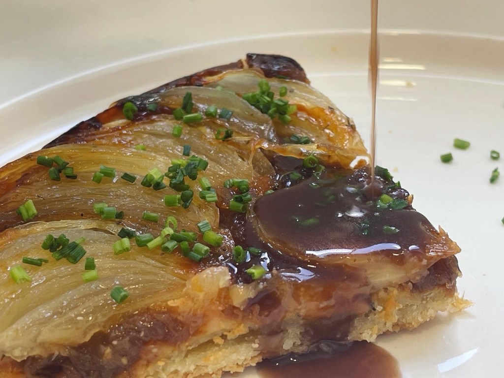 Tarta tatin de cebolla con salsa de carne y vino tinto, y cebollino
